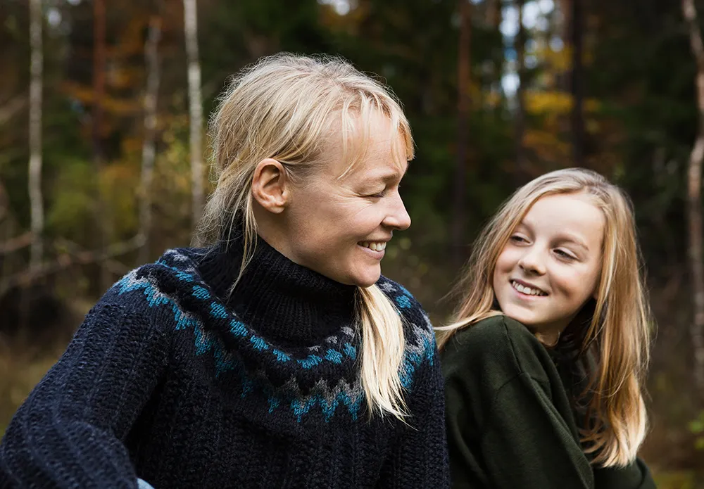 Mother And Daughter Smiling In Forest